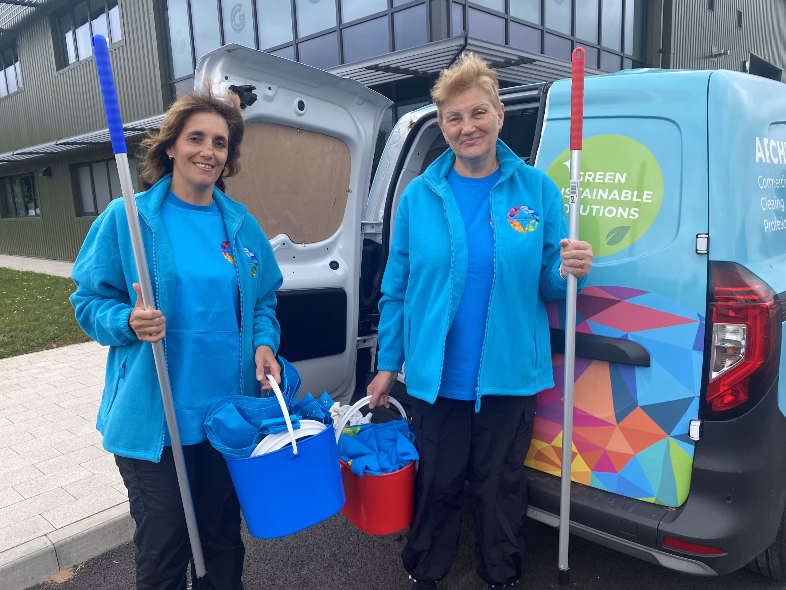 Two women standing by a branded Archway van